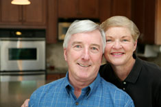 A smiling older couple in their kitchen