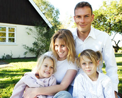 smiling family of four on their front lawn