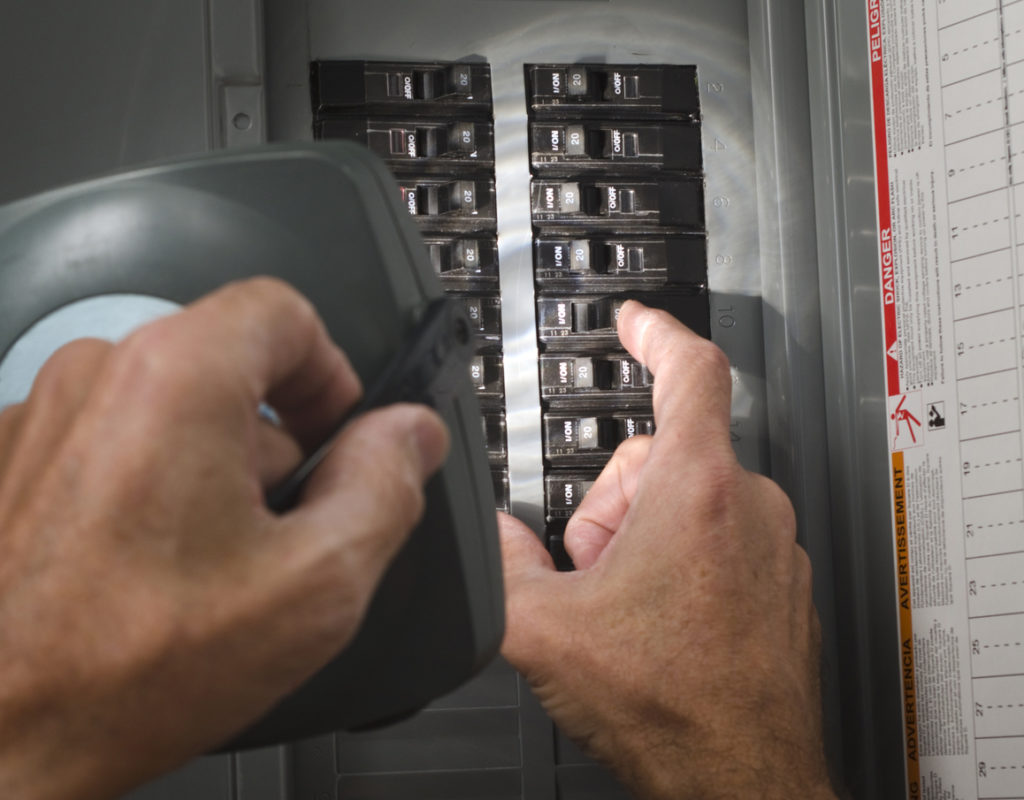 closeup of someone flipping a switch in a panel