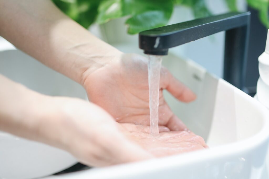 hands in sink under water